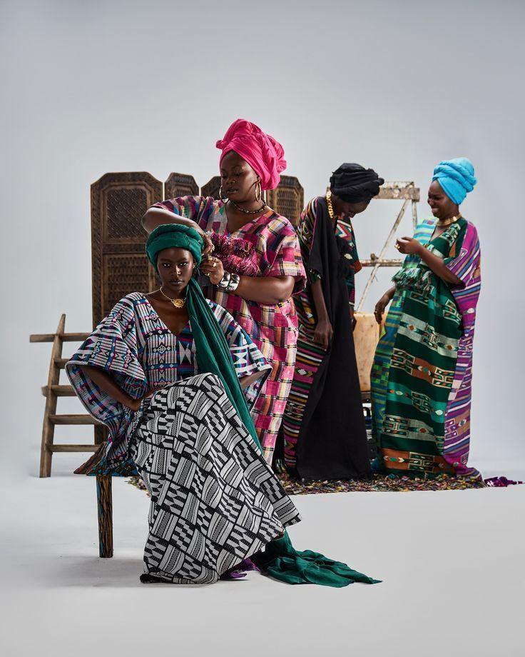 Four women modelling patterned cloth and matching headwraps in a studio